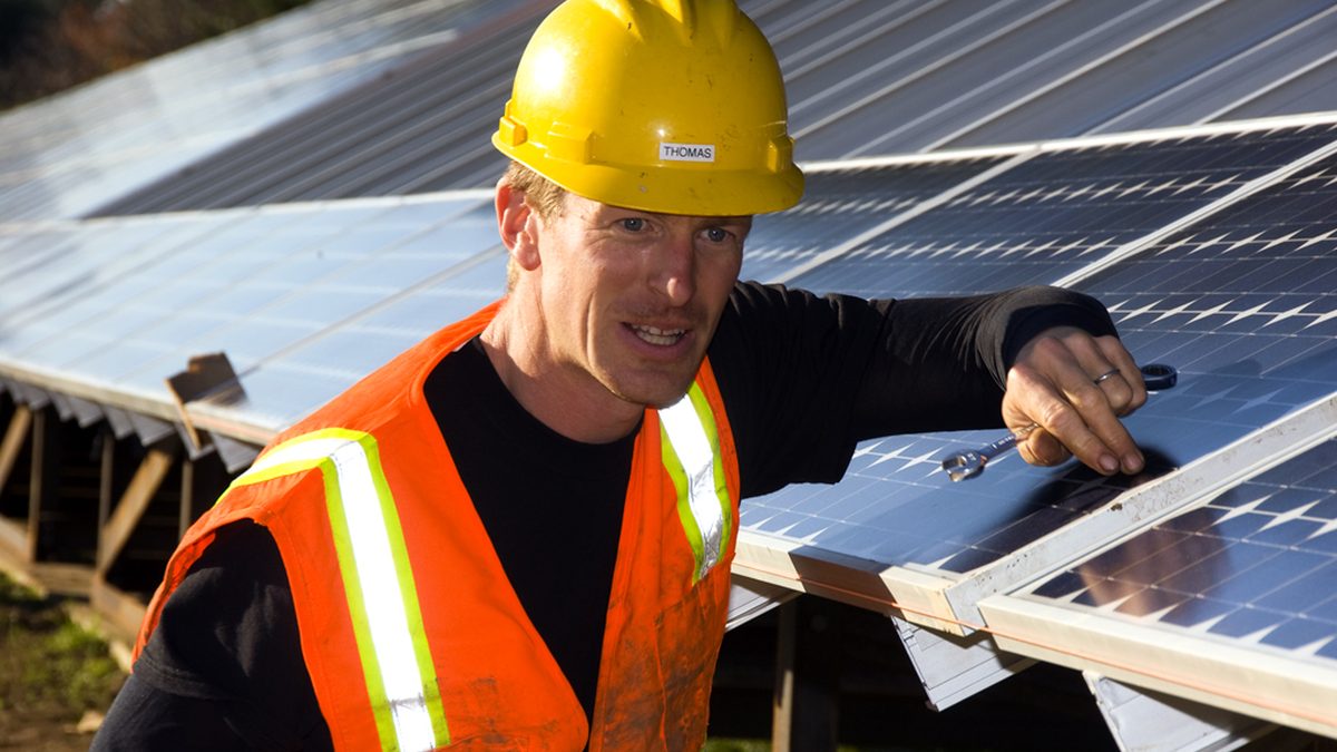 Technicien installant des panneaux photovoltaïques en toiture